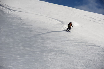 Skier slides down mountains in clear weather