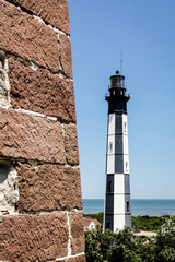 Modern Lighthouse and old lighthouse wall on Cape Henry, Virginia Beach at the juncture of...