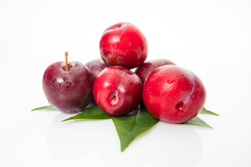 plums with plum leaves on a white background