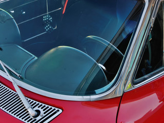 Driver's seat of a classic red sedan.