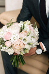 Obraz na płótnie Canvas Wedding bouquet in the hands of the groom, selective focus