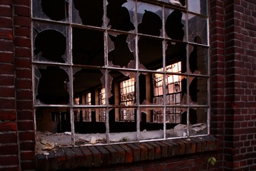 broken window in abandoned brick wall