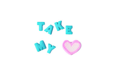 The word TAKE MY HEART made by aqua blue alphabet cookies and pink heart shaped marshmallow on white background