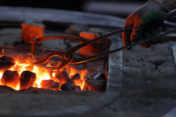 Hot coals in a furnace for heating metal for manual forging in a blacksmith workshop