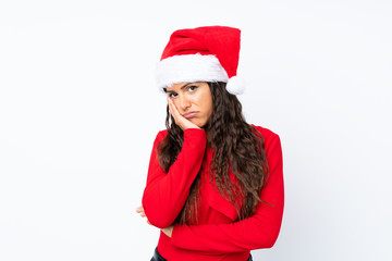 Girl with christmas hat over isolated white background unhappy and frustrated