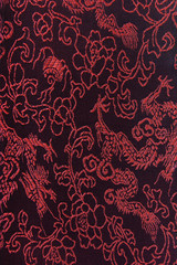 Dragon patterns on dark red-black silk textile