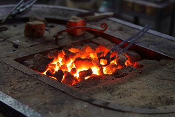 Hot coals in a furnace for heating metal for manual forging in a blacksmith workshop
