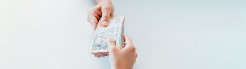Bank credit. Lend borrowing investment. Man receiving bundle of 500 ukrainian hryvnia bills.