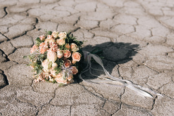 Bride's bouquet on the background of cracked earth