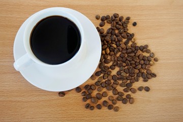 cup of coffee and beans on wooden table
