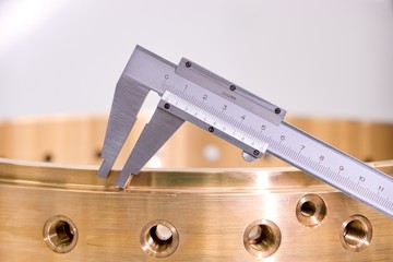Precisely manufactured bronze product, machining and metal dimension measurement.