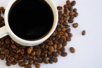 cup of coffee with beans on white background
