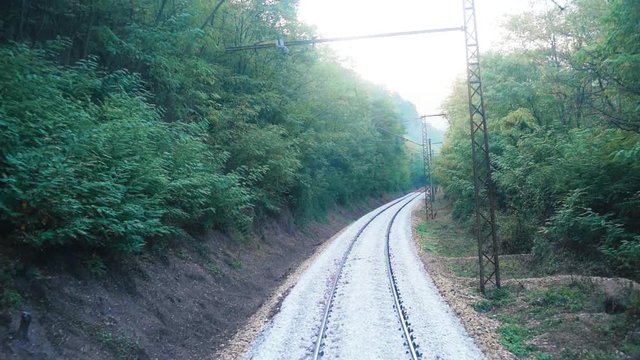 View over a single railroad track through the forested area in Romania
