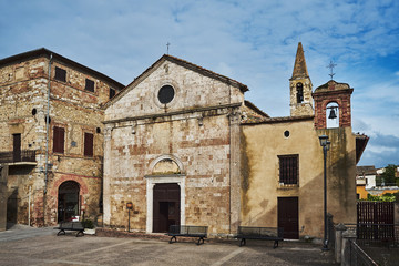 Stone, medieval church with a bell tower in the village of Magliano in Toscana, Italy.