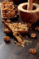 Walnuts in a wooden dish on an old wooden table.
