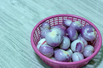 Red onions peeled in to the purple plastic basket.