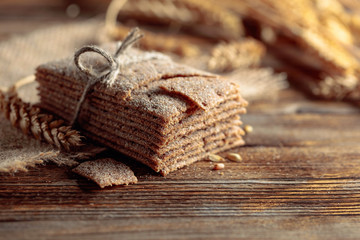 Rye crackers and ears on a old wooden table.