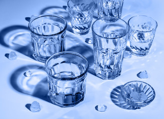 Glass glasses with bright lighting. The blue coloring. Faceted glass.