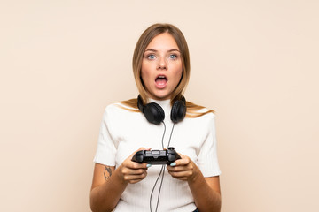 Young blonde woman over isolated background playing at videogames