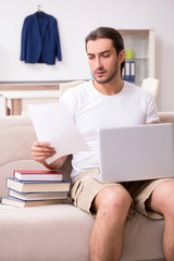 Young male student preparing for exams at home