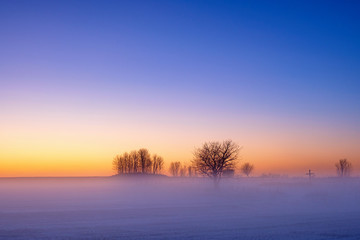 Fototapeta na wymiar Misty sunrise in cold weather at a scenic landscape view