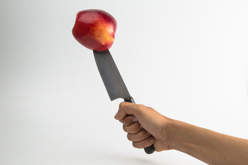 a big knife Cutting red Apple  fruit isolated on white background