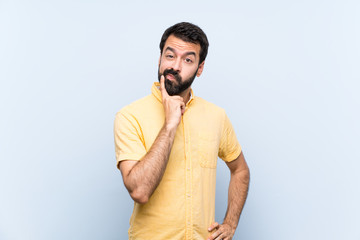 Young man with beard over isolated blue background Looking front
