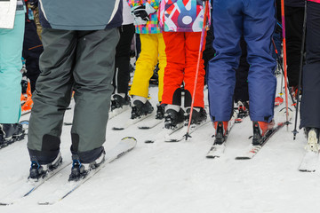 Skiers, adults and children, stand in line for the lift: the concept is a popular sport, crowded on weekends.