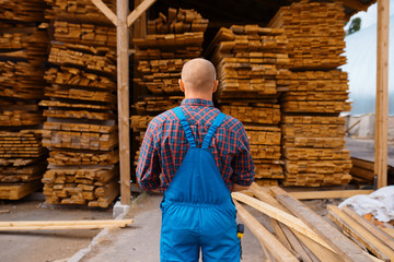 Joiner in uniform check boards on timber mill © Nomad_Soul