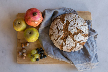A wooden tray with bread and fruits