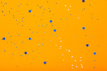 Obraz na płótnie Canvas Orange festive background with blue stars and sparkles. The concept of the celebration, the day of St. Valentine, New Year, birthdays, ceremonies, events, etc.