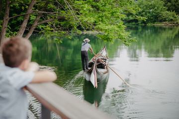 Gondoliere rowing a gondola on a lake in Ulm Germany