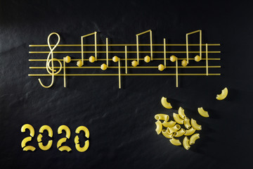 Musical Italian pasta in the form of notes, isolated on a black textural background.