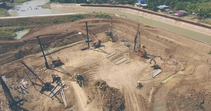  drone shot : fly over the construction site. Heavy machinery, such as drills, excavators, trucks, cranes, and other equipment is used to construct new buildings
