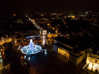 Vilnius, Lithuania, Beautiful Christmas tree decorated with white and blue lights chess queen,  for Christmas 2019 and New Year 2020, market and celebrations in Vilnius Cathedral square from drone.