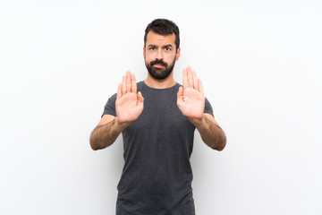 Young handsome man over isolated white background making stop gesture and disappointed