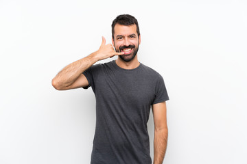 Young handsome man over isolated white background making phone gesture. Call me back sign