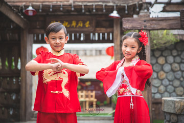 Young chinese boy and girl smiling and happy in lunar new year costume dress