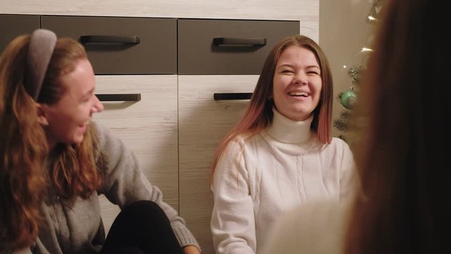 Girls gathering. Winter holidays leisure. Cheerful female friends enjoying fun conversation at home.