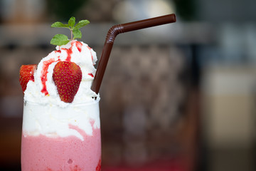 Strawberry milkshake in glass with whipped cream