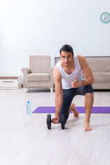 Fototapeta premium Young man training and exercising at home