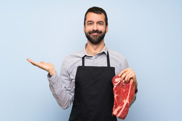 Chef holding a raw meat holding copyspace imaginary on the palm to insert an ad