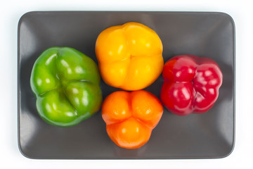 Fresh colored bell peppers on a white and gray background. Vitamin wholesome food.