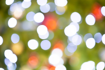 Obraz premium Festive green Christmas tree decorated with red toys balls and yellow lighting. copy space.