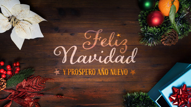 “Feliz Navidad y prospero Año Nuevo”  t.i. Merry Christmas and Happy New Year in French language on a wooden background with decoration vertical view for smartphone digital wishes messages. 16:9 size.