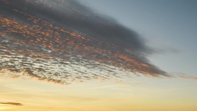 Time lapse following color changing clouds high in thy sky