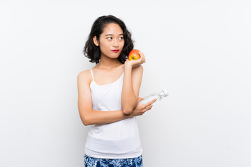 Asian young woman with an apple over isolated white background