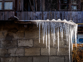 Icicles on the roof of the house from water leakage from a burst pipe