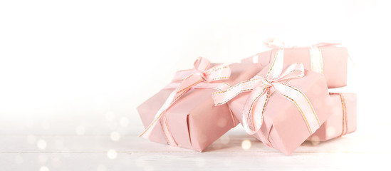 Valentine's Day. Gifts in pink boxes and golden hearts on a light background, festive background, wedding, birthday