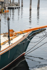 old wooden sailboat tied to dock, hull of a boat. vertical photo